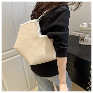 Straw tote bag with white leather trim shown on model for size and capacity scale