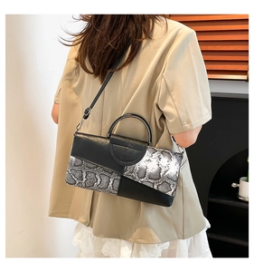 Elegante borsa a tracolla con design patchwork asimmetrico in pelle di serpente bianca e nera