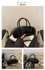 Detail of black glossy patent leather Boston bag with silver hardware and dual handles