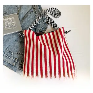 Detail der rot-weiß gestreiften Canvas-Tasche mit geometrisch gemustertem Schultergurt