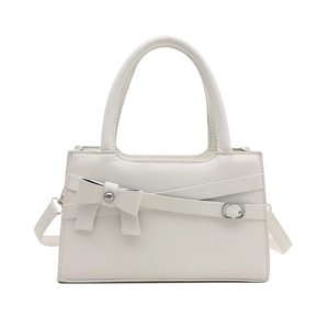 Minimalist beige bow handbag with crossbody strap and gold metal buckle on white background