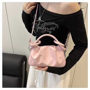 Close-up of pink pleated cloud bag with stylish wrap-around handle and adjustable strap
