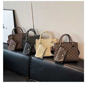 Dettaglio di quattro eleganti borse a mano quadrate con monogramma in vari colori neutri