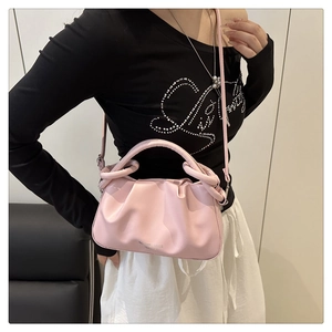Close-up of pink ruched cloud bag with adjustable shoulder strap and top handle design