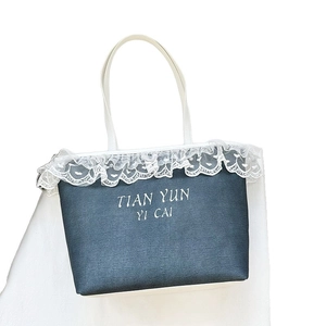 Blue denim tote bag with white lace trim and printed text shown on white background