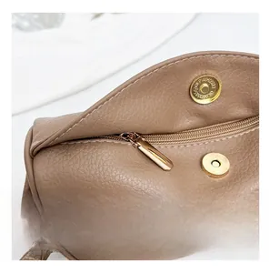 Close-up of brown lychee texture leather with gold zipper and magnetic snap closure