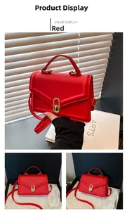 Détail du sac carré en cuir PU rouge avec coutures en V et fermoir rotatif doré