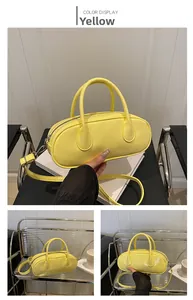 Detailed view of bright yellow glossy leather Boston bag with adjustable shoulder strap