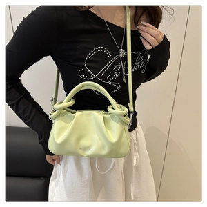 Primo piano della borsa a mano plissettata verde chiaro con texture morbida e logo