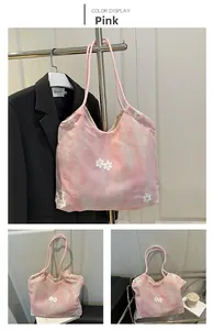Detailed close-up of pink tie-dye fabric tote bag with 3D white floral embroidery