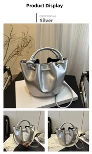 Detail view of a metallic silver bucket bag featuring woven rope handles and a slim strap