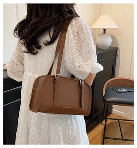 Detail view of brown vintage leather boston bag with golden fashion text and silver buckle