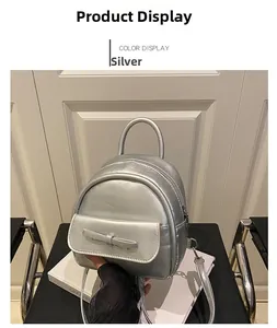 Detail view of mini silver metallic backpack with bow accent and smooth zipper closure
