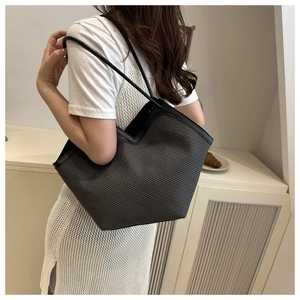 Detail of dark grey woven tote bag featuring unique V-shaped cut and black shoulder strap