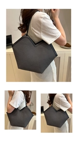 Close-up of dark grey woven tote bag with V-shaped opening and slim leather straps