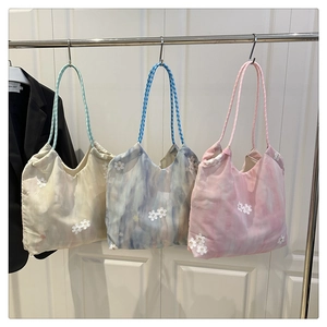 Detailed embroidery of white floral appliques on lightweight tote bags in three colors