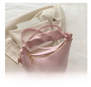 Détail de la poignée plissée du sac à main rose avec texture douce et zip doré