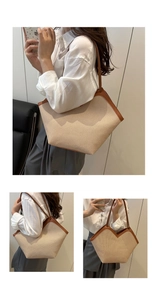 Close-up of large woven tote bag with straw texture and brown leather trim details