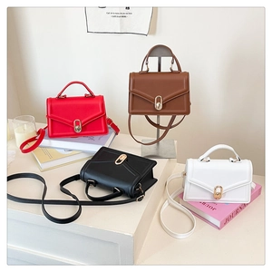 Détail de quatre sacs à bandoulière colorés avec rabat en V et boucles dorées ovales