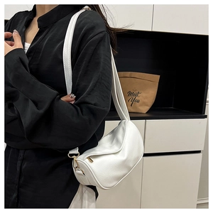 Side view of white lychee leather dumpling bag with slender strap and gold hardware