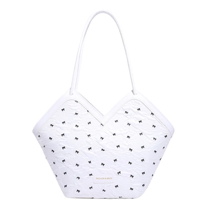 White quilted tote bag with black bow patterns and Fashion & Bags leather tag