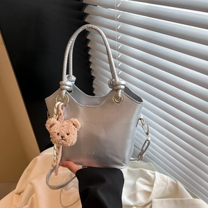 Silver metallic bucket bag with knot handle and teddy bear charm for women