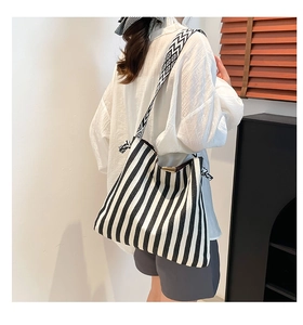 Detailansicht der gestreiften Canvas-Tasche mit geometrisch gemustertem Schultergurt