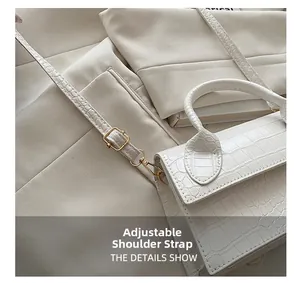 Detail of adjustable shoulder strap with golden buckle on white crocodile pattern bag