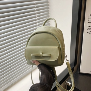 Minimalist light green mini backpack with elegant bow detail and top handle for women