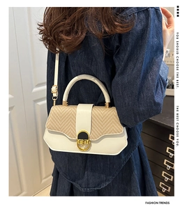 Detail of cream leather and straw woven crossbody bag with metallic circular buckle