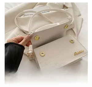 Detail show of white crocodile pattern shoulder bag with gold magnetic closures