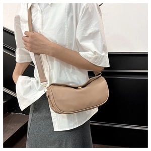 Detail of khaki crescent crossbody bag with lychee texture and gold metal buckle