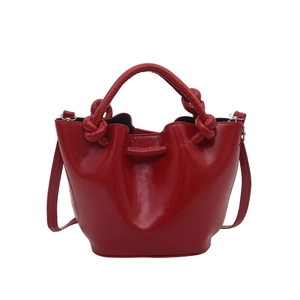 Glossy red bucket bag with knotted handles and drawstring design for summer fashion