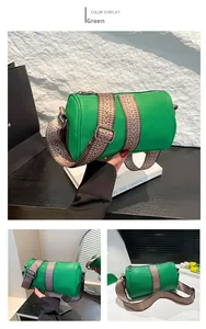 Close-up of green cylinder bag with textured leather and patterned wide shoulder strap