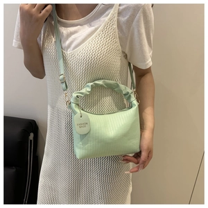 Détail du sac à main vert clair plissé avec texture gaufrée et poignée style nuage