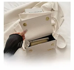 Detail view of the white crocodile pattern handbag showing interior storage capacity