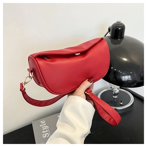 Detailed macro view of red lychee textured synthetic leather on a crescent handbag