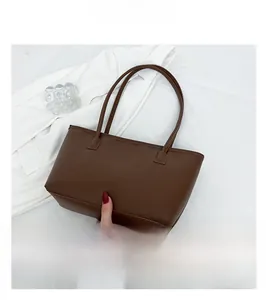 Detailed view of the brown leather tote bag with long handles and a smooth texture