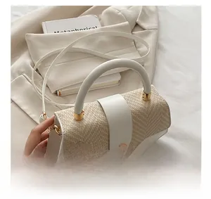 Detail of cream woven handbag with gold hardware and stylish cylindrical handle