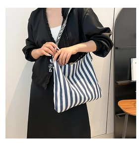 Detailansicht der gestreiften Canvas-Tasche mit geometrisch gemustertem breitem Gurt
