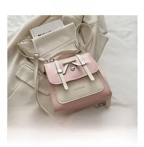Detailed view of pink and beige two-tone shoulder bag with heart pendant and bow