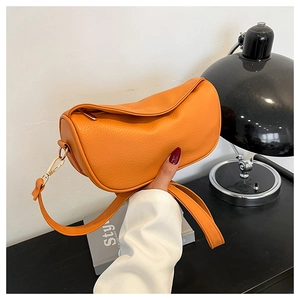 Detail of orange pebble leather crossbody bag featuring premium gold hardware and zipper