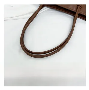 Detail view of smooth brown leather shoulder straps with finished edge oiling process