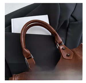 Détails du similicuir marron avec rivets métalliques et chaîne noire sur le sac à main