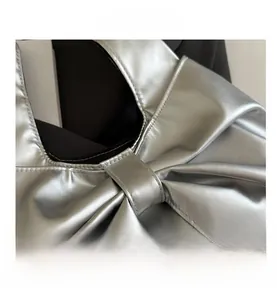 Detailed macro view of silver metallic leather texture and bow-knot pleat craftsmanship