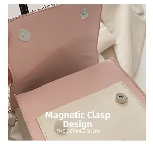 Detail shot of the dual magnetic buckle design on this stylish pink and beige PU handbag