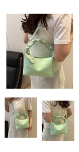 Détail du sac à main plissé vert menthe avec rayures verticales et étiquette coeur