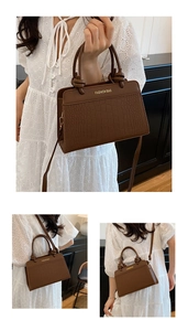 Detail of dark brown faux crocodile leather tote with elegant knotted handles and long strap