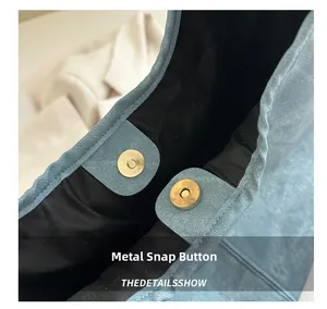 Detail of golden magnetic closure on blue matte leather tote bag for women