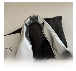 Macro detail of silver textured leather tote bag with stitching on handle